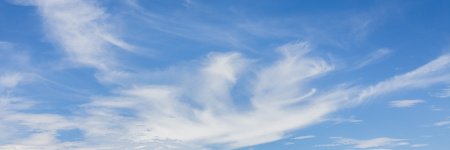 A landscape image of a blue sky with wispy clouds 